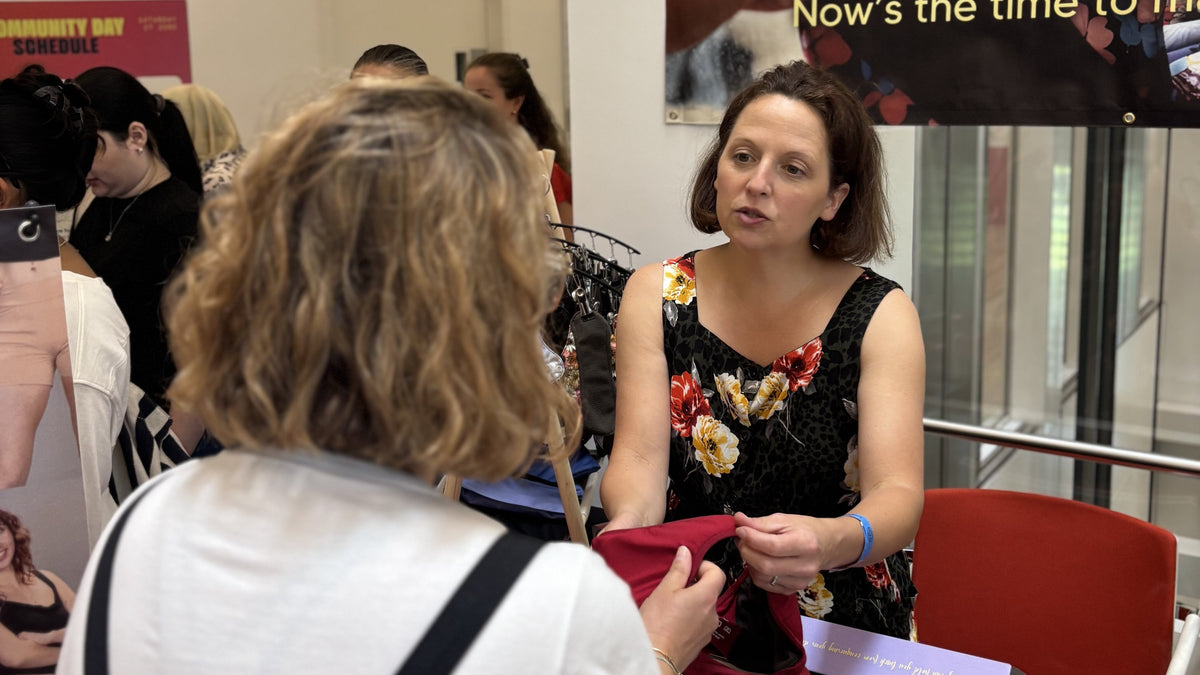 Mighty Eve team member showing period pants to a visitor at the Earthfest Community Day stall, Aga Khan Centre, 27 June 2026.