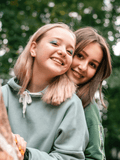 Period Starter Kit - MightyEve  Two teens hugging outdoors with a blurred green background