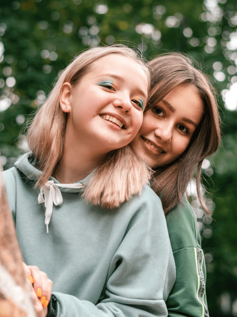 Period Starter Kit - MightyEve  Two teens hugging outdoors with a blurred green background