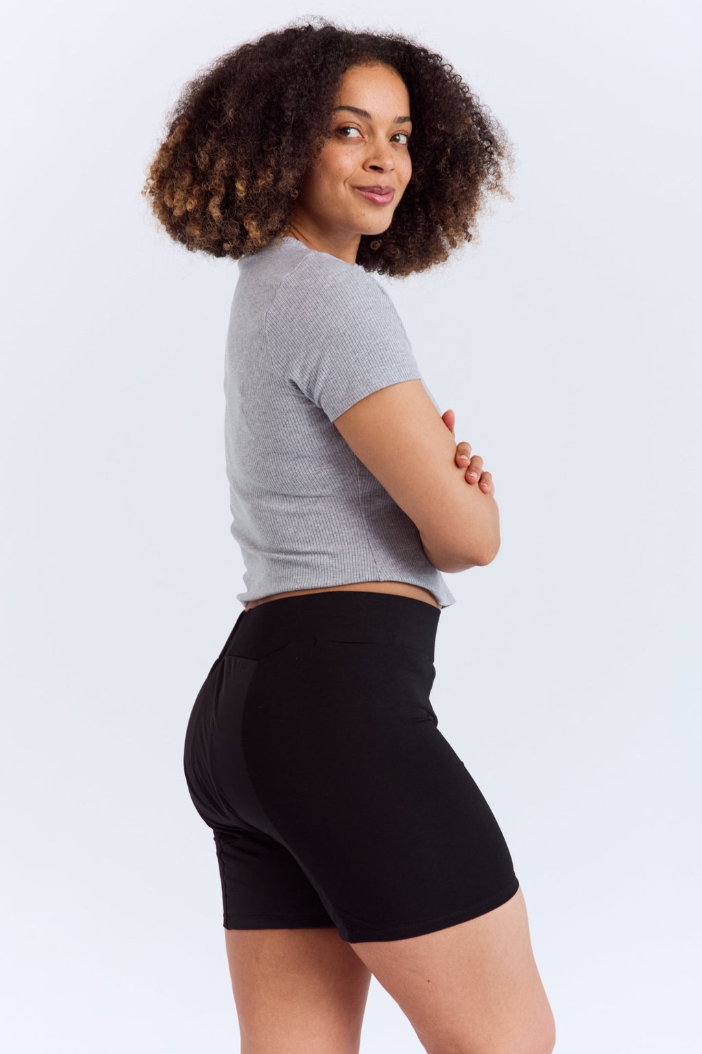 Mighty Gusher Period Shorts - MightyEve GSS01 Woman wearing a gray crop top and black period shorts on a white background