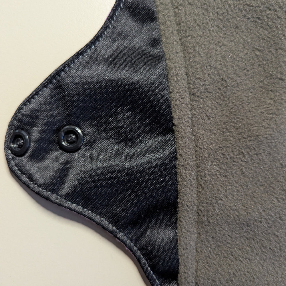 Close-up of a mighty eve period pad with popper closure on a light background.