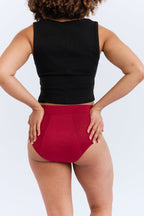 New Membership Offer - MightyEve  Woman wearing a black sleeveless top and red period underwear on a white background