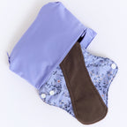 Mighty Heavy Night Popper Pad - MightyEve PPXL02P Reusable menstrual pad with a floral pattern and a brown interior, placed inside a matching wash clutch bag on a white background.