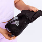 New Membership Offer - MightyEve  Person holding a black mesh wash clutch bag on a white background